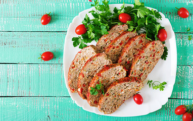 American food. Homemade ground beef meatloaf with ketchup and bell peppers. Meat loaf on white plate. Top view. Flat lay