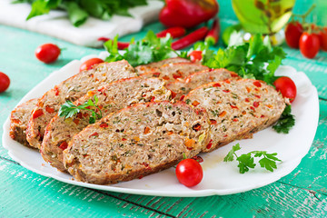 American food. Homemade ground beef meatloaf with ketchup and bell peppers. Meat loaf on white plate.
