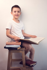 Yound kid reading interesting book at walk. Concept of reading an interesting and exciting book everywhere.