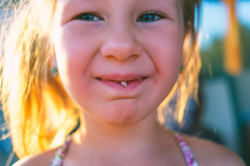 Obraz premium Portrait of a little girl with an outstretched milk tooth