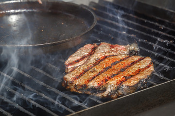 Meat fillet of a barbecue is cooked with smoke in the open air