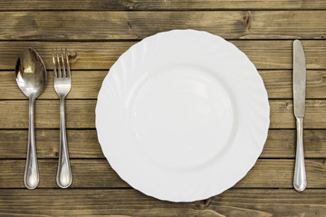 Empty dish and cutlery on wooden background closeup