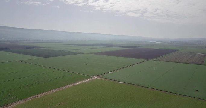 Flying over Hula Valley and Golan heights 
Hula Valley, Wheat fields and Golan Heights in background, drone shot, Israel
