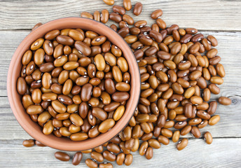 Haricot beans in bowl on wooden background