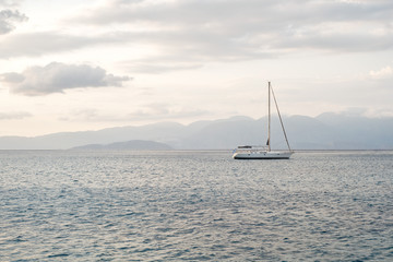 sea, mountains landscape, sailboat sailing far from seashore