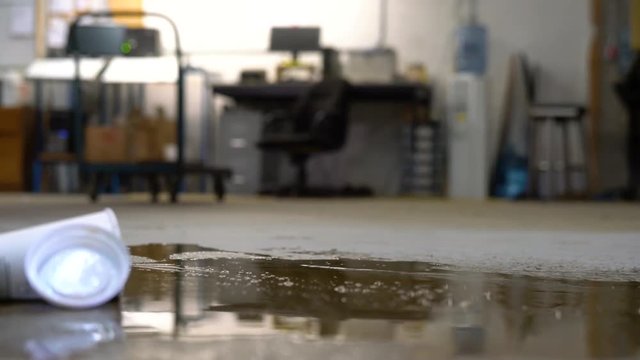 A warehouse worker slipping on spilled liquid
