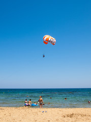  tourists on a parachute above the  beach in Malia. Crete, Greece