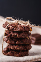 Chocolate chip chocolate cookies with chocolate pieces and milk on a vintage background. Moody...