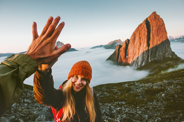 Couple friends giving five hands traveling outdoor hiking in Norway mountains adventure lifestyle...