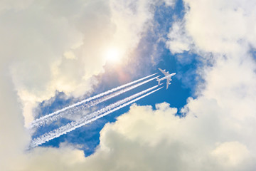 Airplane flies high in the sky, a journey through the clouds and a sunny glare.