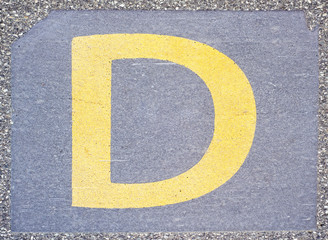 Letter D painted on the concrete pavement at the train station