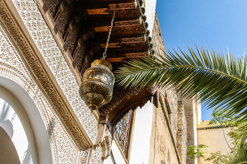 Close up of Moroccan architecture, elaborate silver lantern light and desert palm in Fez, Morocco © Lindsay