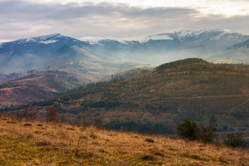 gloomy november scenery in mountains. foggy and hazy forenoon on an overcast day. distant mountain tops in snow