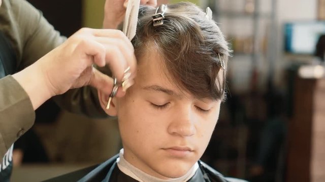 Hairdresser for men. Barbershop. A young man is cut hair in a hairdresser.