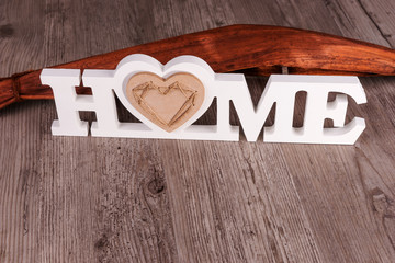 Word Home in white letters on dark wooden background