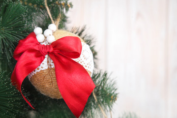 Christmas or New Year rustic wooden background with toy decorations and fur tree branch.