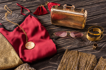 close up view of arrangement of golden and red fashionable feminine accessories and clothes on...