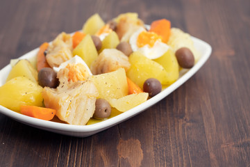 cod fish with boiled egg and vegetables on white dish