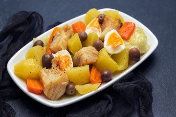 cod fish with boiled egg and vegetables on white dish