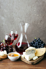 Cheese, wine and honey, wooden board, gray background, snack, alcohol, dairy products