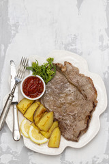 grilled meat with potato and sauce on white dish