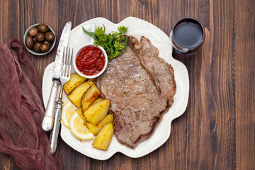 grilled meat with potato and sauce on white dish