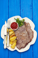 grilled meat with potato and sauce on white dish