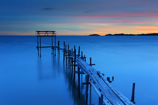 Beautiful sunset at old wooden bridge on sea coast © isarescheewin