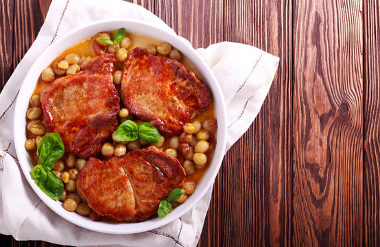 Pork steaks with grapes in baking tin