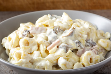 Ravioli with mushrooms and ham in a cream and cheese sauce