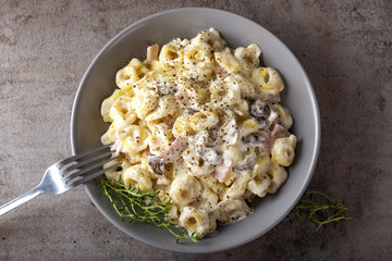 Ravioli with mushrooms and ham in a cream and cheese sauce