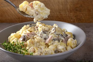 Ravioli with mushrooms and ham in a cream and cheese sauce