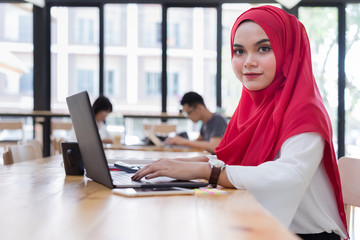 portrait of young muslim business people wearing red hijab,working in coworking space.