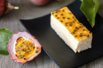 Passion fruits cheese cake slice , on dark plate