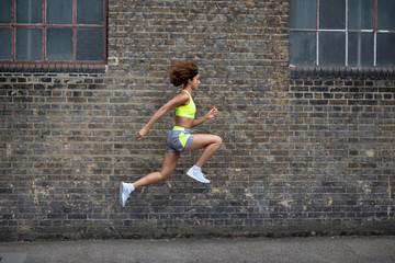Side view of female athlete leaping in the air
