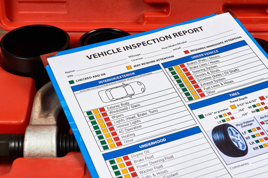 Vehicle vehicle inspection report form against the background of automotive tools. Close up.
