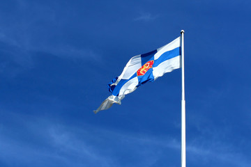 Fototapeta premium Flag of Finland in the wind against the blue sky