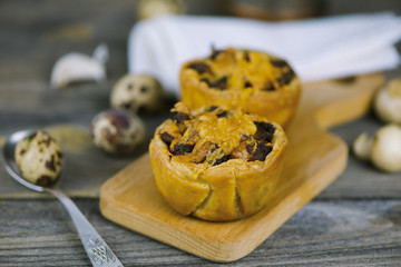 Baked puff pastry with meat stuffing and cheese on a wooden board