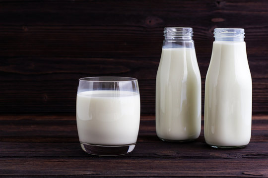A Glass and Bottle of milk on wooden background.