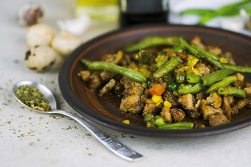 fried meat with vegetables and asparagus with spices on a plate