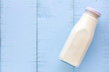 A bottle of milk on blue wooden background.
