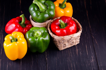 Three sweet peppers on a wooden background,