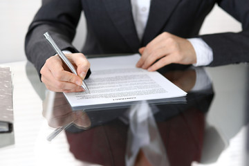 Close-up of female hands with pen over document of contact, business concept