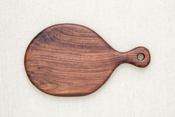 A handmade black walnut wooden chopping board on burlap
