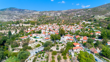 Fototapeta na wymiar Aerial Lania (Laneia) wine village, Limassol, Cyprus. Bird's eye view of traditional Mediterranean, picturesque alleys, red ceramic roof tile houses, vineyards, church and entrance to the village.