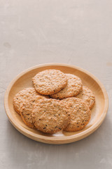 Oat cookies in plate isolated on white background, top view. Sweet bakery products. Round cookies in a wooden plate.