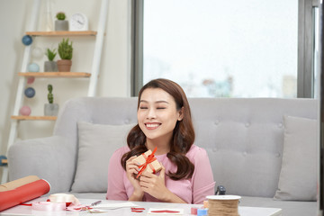  Happy young woman pressing gift box to her chest