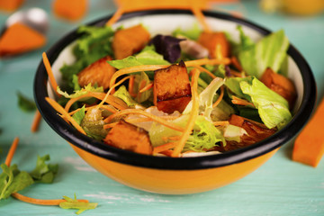 salad of fresh vegetables and baked pumpkin in a plate