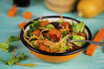 salad of fresh vegetables and baked pumpkin in a plate