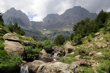 Fototapeta na wymiar The Piedrafita de Jaca lake and Barranco Cuasta river with the Pena Telera massif in the aragonese Pyrenees mountains